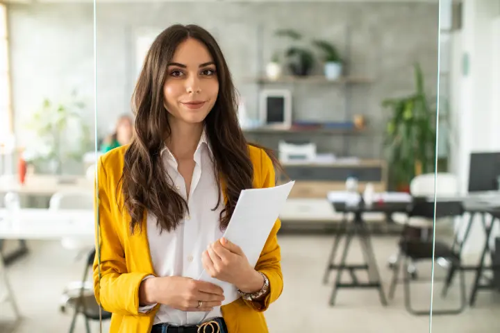 Smiling employee holding her required training overview